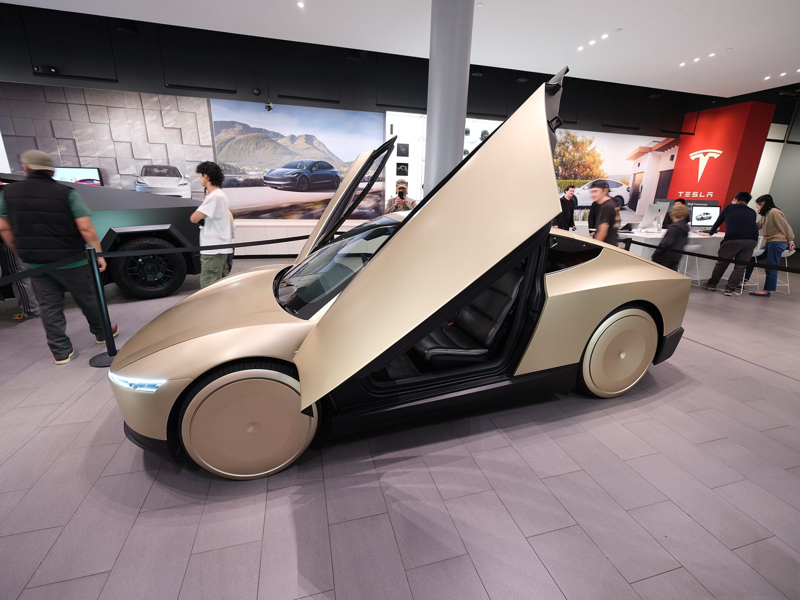 Tesla Cybercab with butterfly doors open in a showroom
